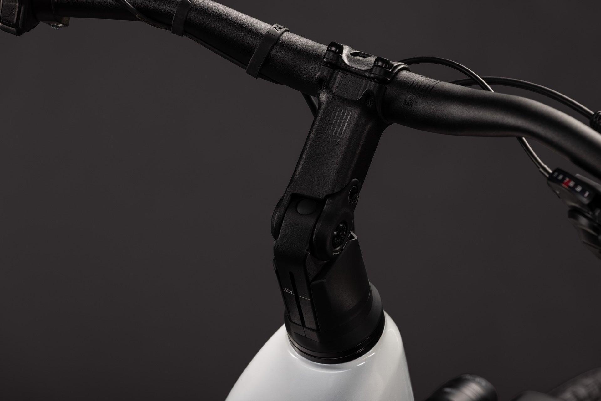 CUBE Touring Hybrid ONE 600: schwarzer Lenker am weißen E-Bike-Rahmen in Nahaufnahme